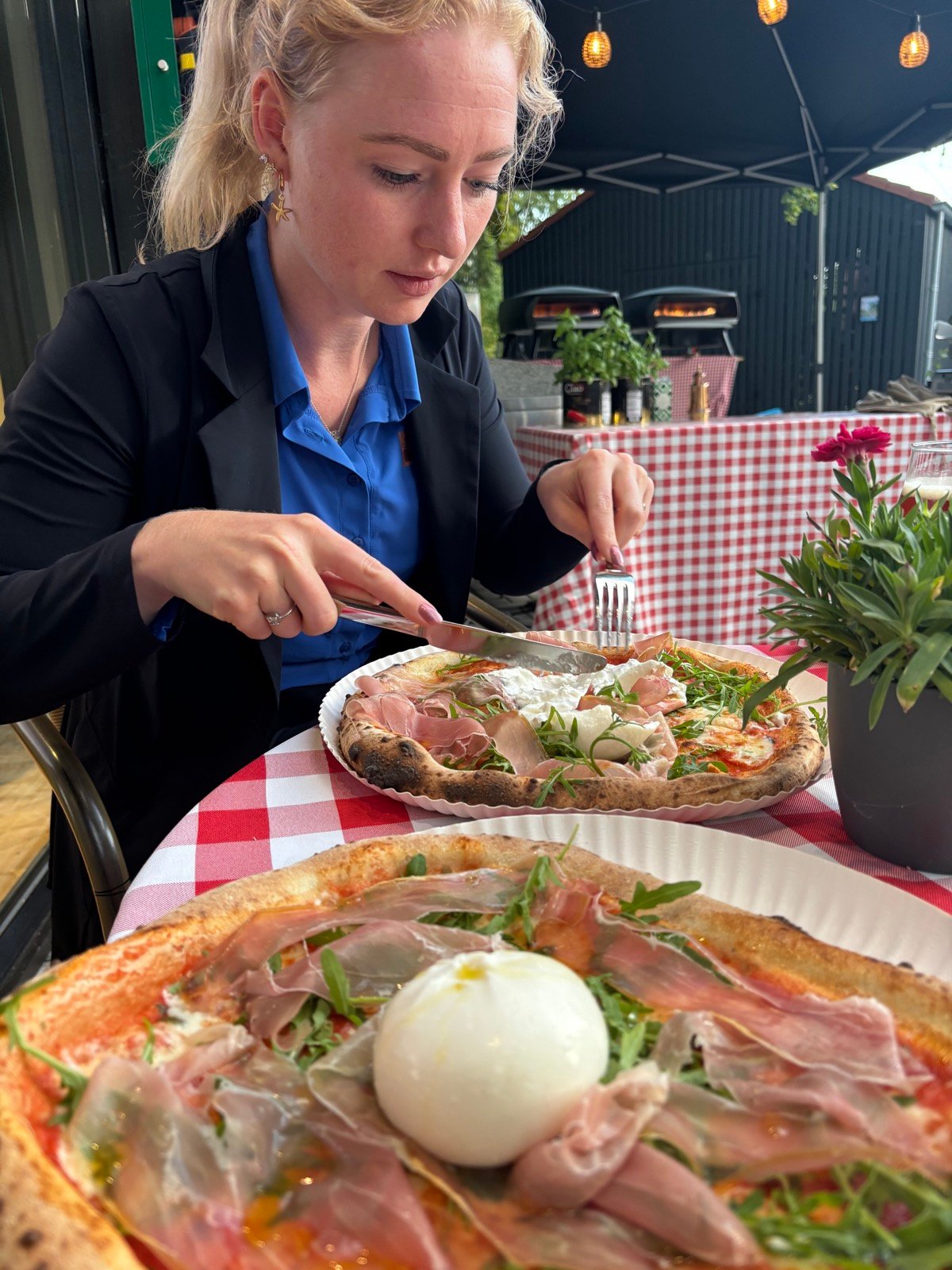 Daphne eet pizza op een terras