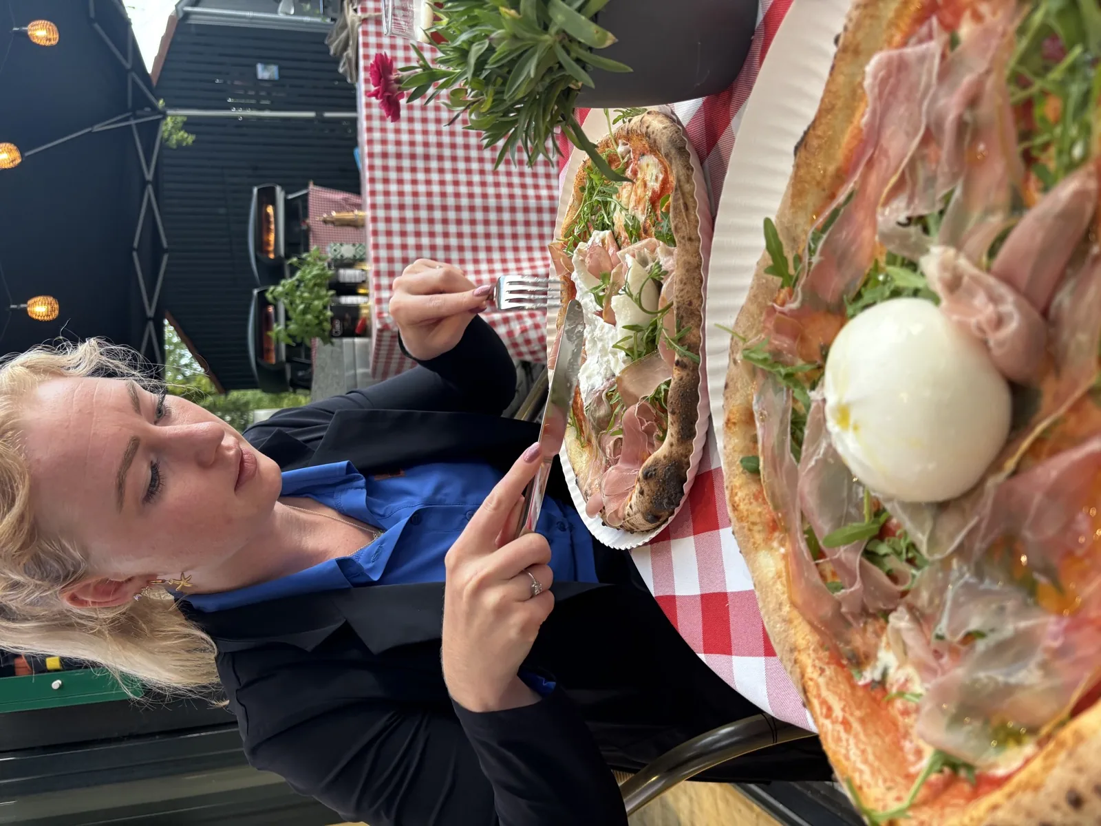 Daphne eet pizza op een terras